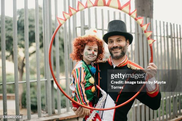 father and son dressed as clown and tamer with a ring of fire - zirkus kinder stock-fotos und bilder