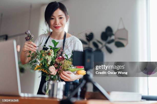 female florist vlogger recording flowers arrangement video - england media access stock pictures, royalty-free photos & images