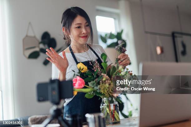 female florist vlogger recording flowers arrangement video - flower arrangement stock pictures, royalty-free photos & images