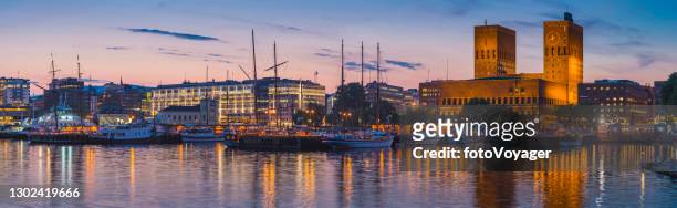 oslo hafen ufer panorama marina rathaus beleuchtet nacht norwegen - oslo city hall stock-fotos und bilder