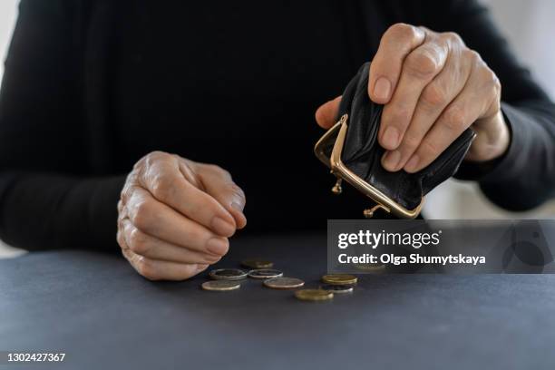 an elderly woman holds an open empty wallet in her hands, the concept of poverty, pension - aumône photos et images de collection