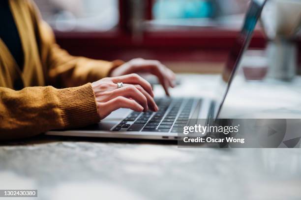 closeup shot of an unrecognizable woman using laptop - mujer escritorio fotografías e imágenes de stock