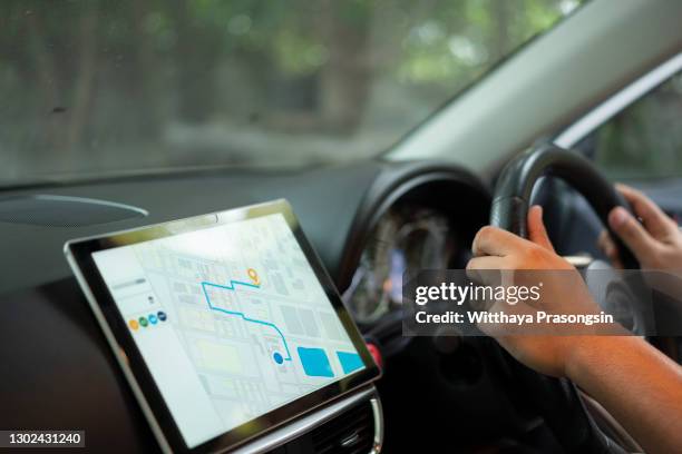 the map on the phone in the background of the dashboard. black mobile phone with map gps navigation fixed in the mounting. app map for travel. - navigatore foto e immagini stock