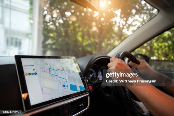 person driving a car with gps navigation - système gps photos et images de collection