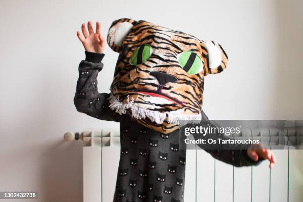 girl in a black cat dress playing at home dressed up with a handmade cat face cushion - animal representation stock pictures, royalty-free photos & images