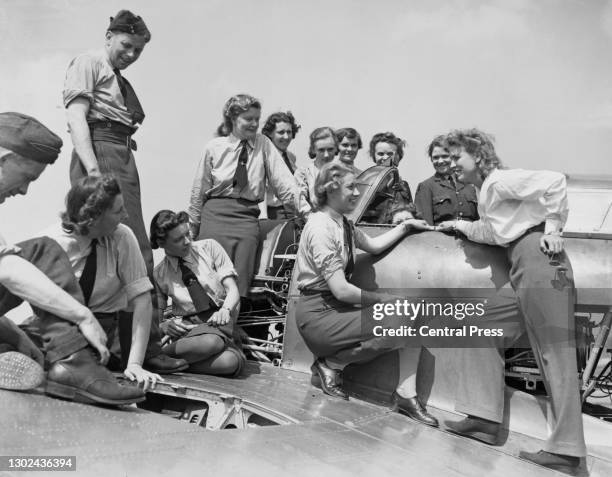 Far right, American pilot Jacqueline Cochran talks to members of the Women's Auxiliary Air Force at work on a Hawker Hurricane MkIIb fighter aircraft...