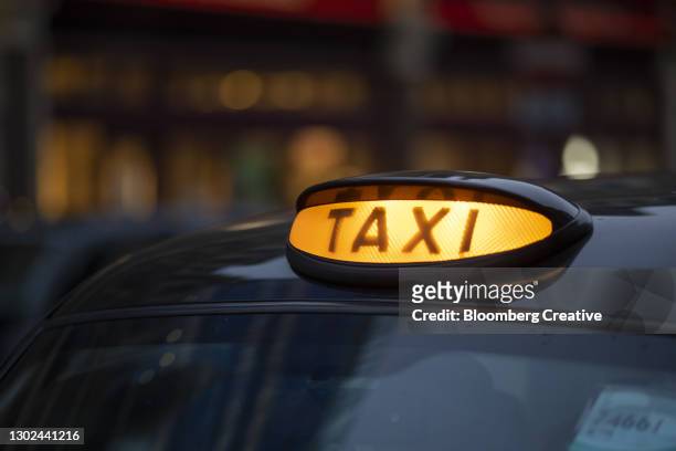 taxi sign on a traditional black cab - london taxi stock pictures, royalty-free photos & images