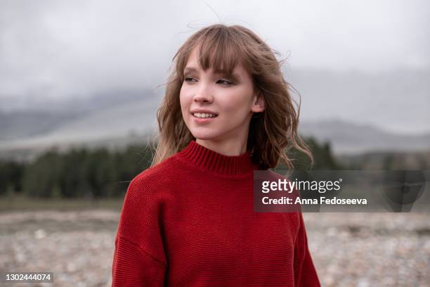portrait of a young girl. mountain altai nature. tourist trip. beautiful girl in a red knitted sweater. - eastern european 個照片及圖片檔