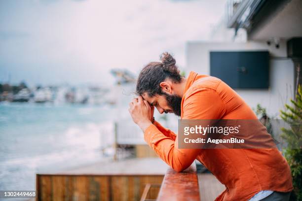 gedeprimeerde mens door het balkon - depressie landelement stockfoto's en -beelden