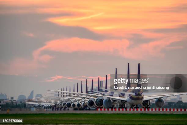 so many airplanes are in line on the runway waiting for take off. these air force planes are part of operation stop service to transport in covid-19 situation. - air strip stock pictures, royalty-free photos & images