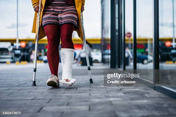 woman walking with cast on foot - orthopedic cast stock pictures, royalty-free photos & images