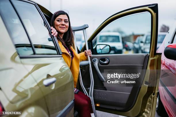 woman with cast getting out of car - crutches stock pictures, royalty-free photos & images