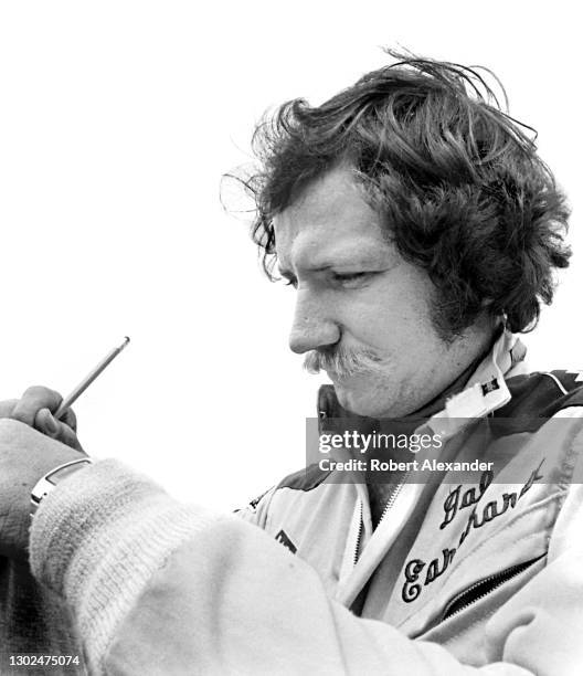 Driver Dale Earnhardt Sr. Signs an autograph prior to the start of the 1981 Firecracker 400 stock car race at Daytona International Speedway in...