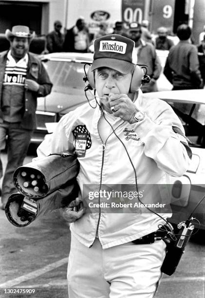 Official and chief flagman Harold Kinder walks in the speedway garage area prior to the start of the 1981 Firecracker 400 stock car race at Daytona...