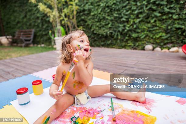 cheerful little girl have fun with acrylic paint on a summer day - baby paint stock pictures, royalty-free photos & images