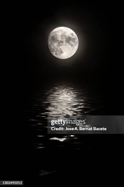 full frame of the full moon in the sky reflected on a water surface. - soy luna fotografías e imágenes de stock