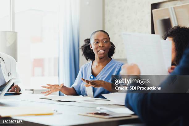 diverse healthcare professionals discuss patient treatment plans at meeting - staff meeting stock pictures, royalty-free photos & images