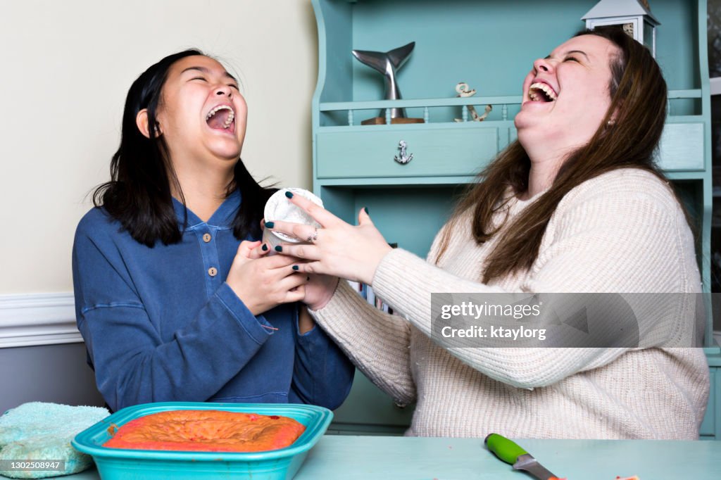 Playful teens bust out laughing while spending the day baking during the Covid lockdown