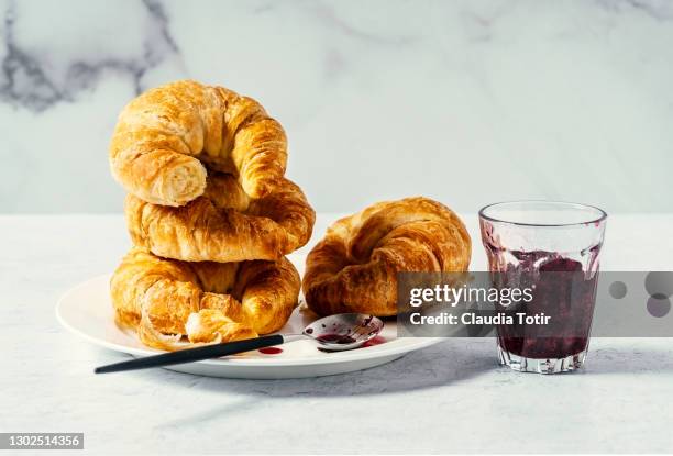 stacked croissants on a plate on white background - croissant white background stockfoto's en -beelden