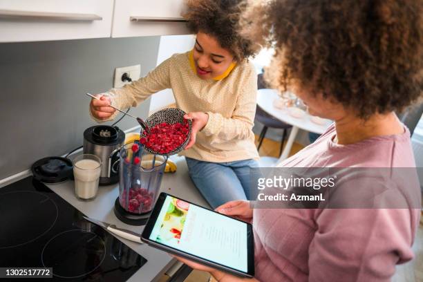 family eating and enjoying smoothie bowl at home - mixer stock pictures, royalty-free photos & images