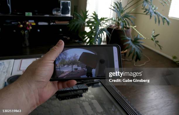 pov watching package delivered through doorbell camera - looking to the camera imagens e fotografias de stock