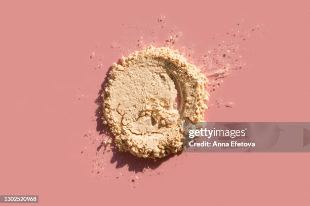 spot of crushed face powder on pink background. trendy selfcare products of the year - makeup brush stock-fotos und bilder