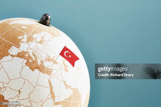 a world globe with a turkish flag pin showing turkey - bandera turca fotografías e imágenes de stock