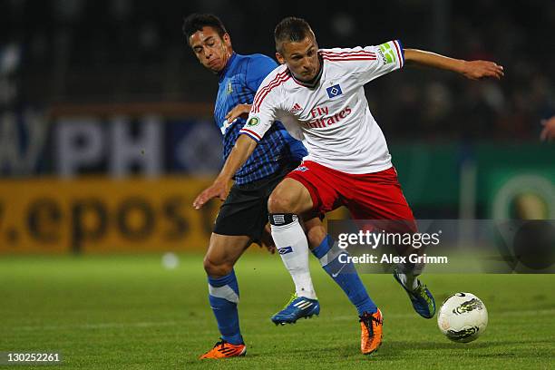 Robert Tesche of Hamburg is challenged by Chhunly Pagenburg of Trier during the DFB Cup second round match between Eintracht Trier and Hamburger SV...