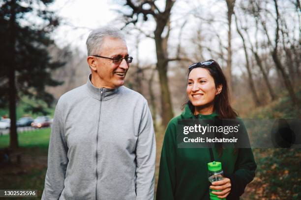 hogere vader en dochter die samen in openlucht opleiden - old man young woman stockfoto's en -beelden