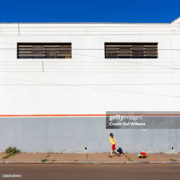 wall in brazil. boy with toy truck running in the street - ribeirão preto stock pictures, royalty-free photos & images