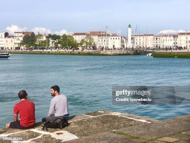 due amici seduti al porto di la rochelle - charente foto e immagini stock