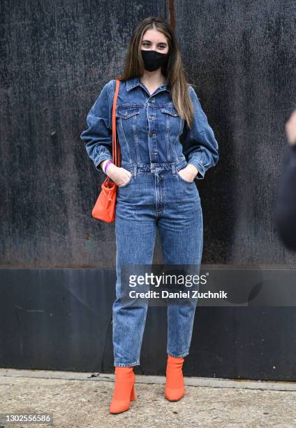 Guest is seen wearing a blue jean one piece outfit and orange boots outside the Rebecca Minkoff show during New York Fashion Week F/W21 at Spring...