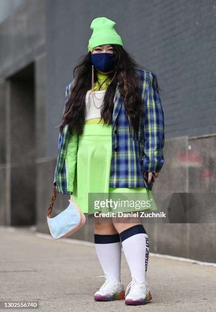 Scarlett Hao is seen wearing a bright green beanie, plaid jacket, green skirt and white sneakers outside the Rebecca Minkoff show during New York...