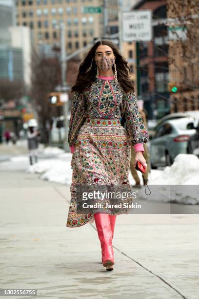Caroline Vazzana wears a pink lined Alice and Olivia print dress and matching pink leather boots outside of Spring Studios on February 16, 2021 in...