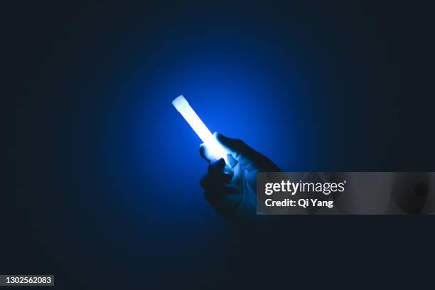 holding a glow stick in the dark - power supply ストックフォトと画像