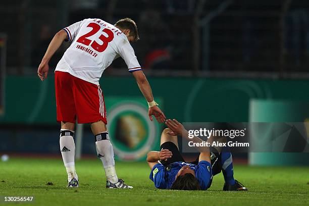 Slobodan Rajkovic of Hamburg comforts Oliver Stang of Trier during the DFB Cup second round match between Eintracht Trier and Hamburger SV at...