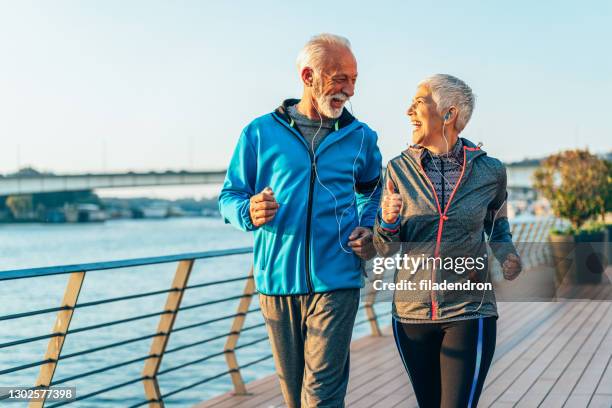 sport outdoor - middle age couple jogging stock pictures, royalty-free photos & images