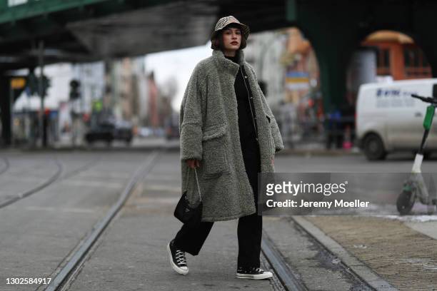 Lea Naumann wearing Prada bag, Burberry hat, Converse sneaker, Diesel green teddy coat and Samsoe Samsoe pants on February 15, 2021 in Berlin,...