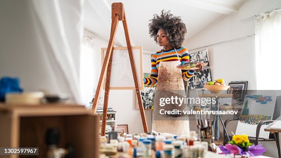 Afro pintor de bellas artes dibujo en estudio, sosteniendo paleta de colores. Afro pintor de bellas artes dibujo en estudio, sosteniendo paleta de colores.