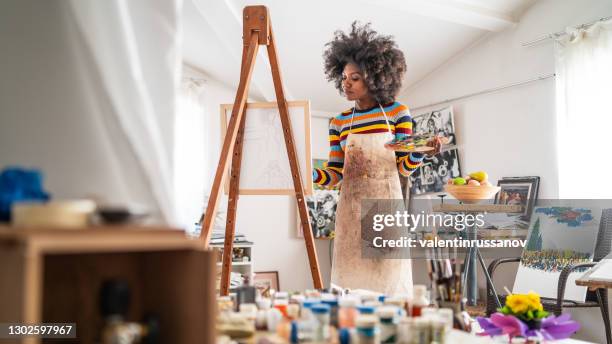 afro pintor de bellas artes dibujo en estudio, sosteniendo paleta de colores. - oficio artístico fotografías e imágenes de stock