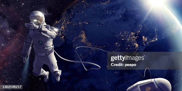 astronaut auf weltraumspaziergang mit selfie vor der erde - astronaut helmet stock-fotos und bilder