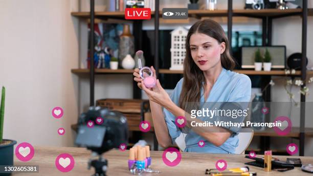 woman does makeup while recording live stream with video player interface - facebook advertisement stock pictures, royalty-free photos & images