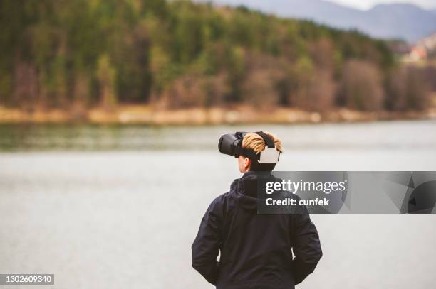 virtuelle realität in der nähe des sees - vr goggles woman stock-fotos und bilder