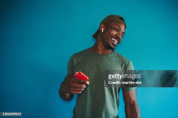 cheerful man listening to music on phone - bulgaria dance stock pictures, royalty-free photos & images