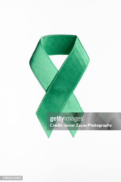 jade awareness ribbon on white background - liver cancer stock-fotos und bilder