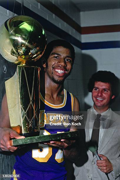 Magic Johnson of the Los Angeles Lakers celebrates with the trophy after winning the NBA Championship during Game Six of the 1985 NBA Finals on June...