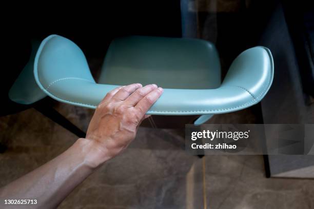 looking down at a person's hand touching the chair - back of chair stock pictures, royalty-free photos & images