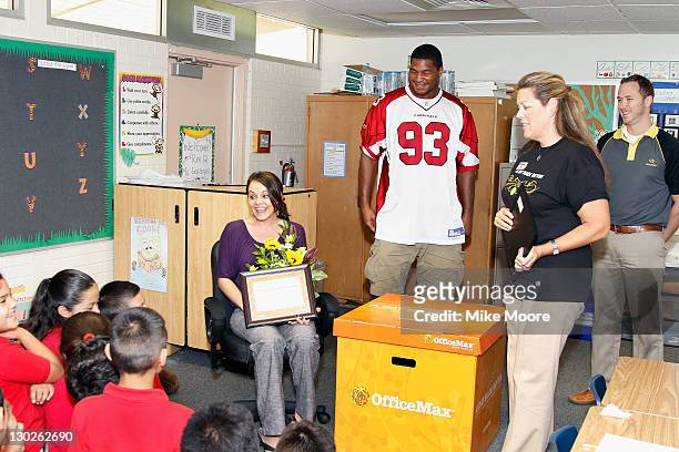 Cardinals Player Calais Campbel looks on as Office Max team member Kelli Roy reads a poem to winning teacher Andrea Gallegos during the Office Max "A...