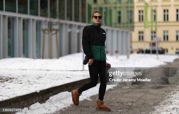 Anna Winter wearing The North Face green vest, Prada bag, Ugg boots, Nike black sweater and Filipa K leggings on February 15, 2021 in Berlin, Germany.