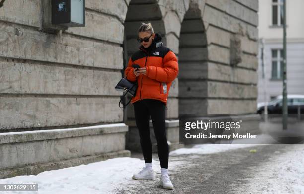 Alessa Winter wearing The North Face orange jacket, white Nike Air Force sneaker, Balenciaga black bag and black Ellesse leggings on February 15,...